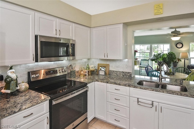 kitchen with white cabinets, decorative backsplash, sink, and stainless steel appliances