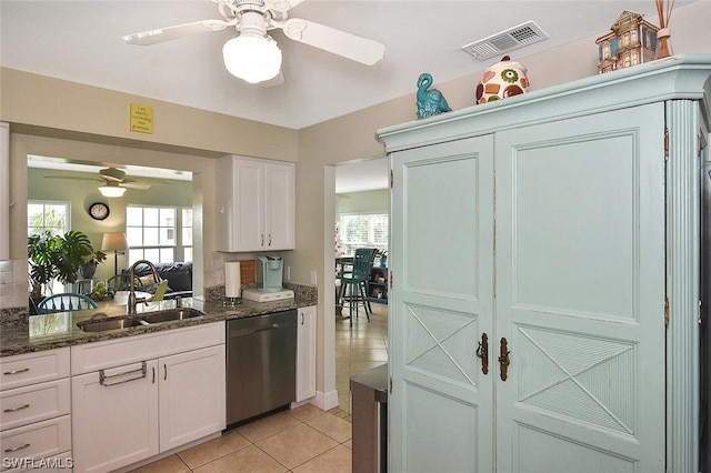 kitchen featuring white cabinetry, stainless steel dishwasher, dark stone countertops, and sink