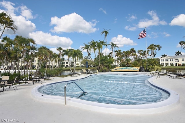 view of swimming pool with a patio and a water view