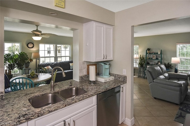 kitchen with dishwasher, white cabinets, dark stone countertops, and sink