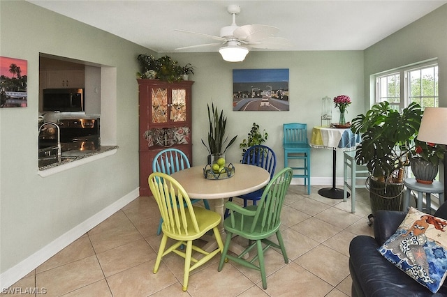 dining space featuring light tile patterned floors, ceiling fan, and sink