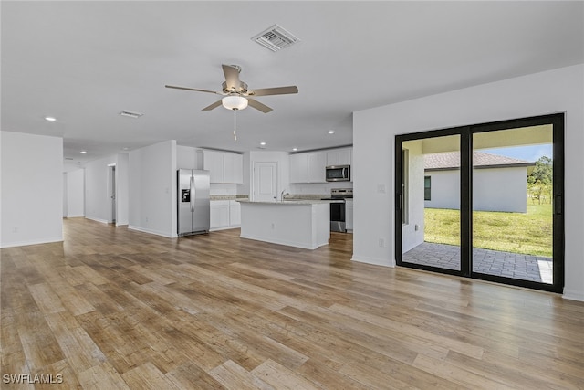 unfurnished living room featuring ceiling fan and light hardwood / wood-style floors