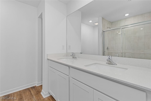 bathroom with vanity, a shower with shower door, and hardwood / wood-style flooring