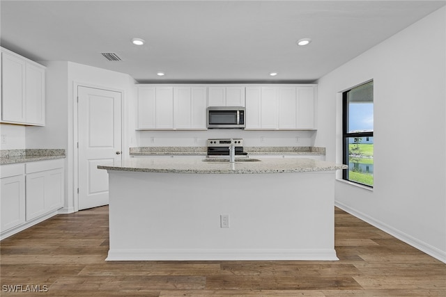 kitchen featuring a center island with sink, stainless steel appliances, sink, hardwood / wood-style flooring, and white cabinets