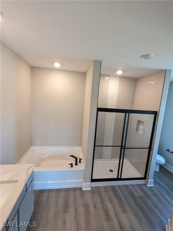 full bathroom featuring vanity, wood-type flooring, toilet, and separate shower and tub