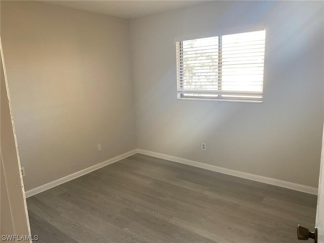 unfurnished room featuring dark wood-type flooring