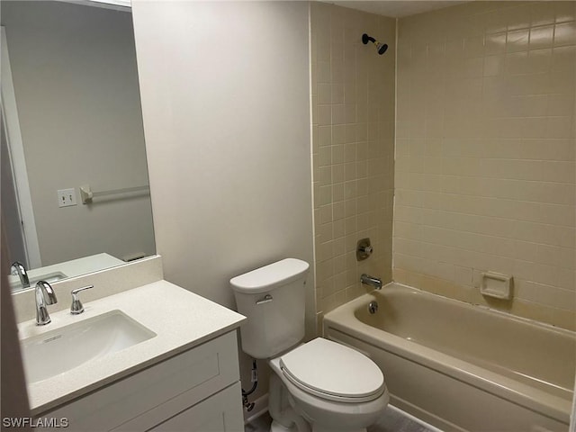 full bathroom with tiled shower / bath, vanity, and toilet