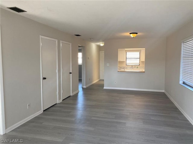 unfurnished room featuring sink and wood-type flooring