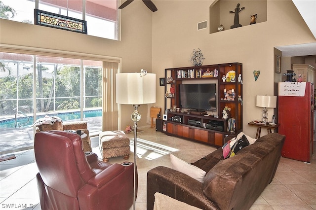 tiled living room featuring ceiling fan and a towering ceiling