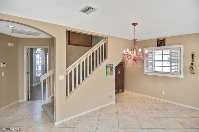 interior space featuring light tile patterned floors and a notable chandelier