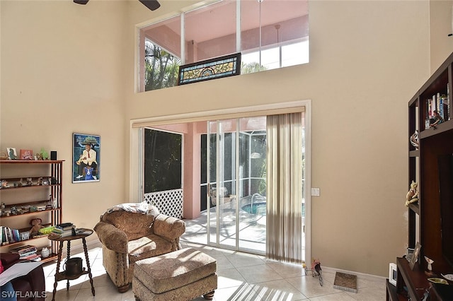 living room featuring light tile patterned floors and a towering ceiling