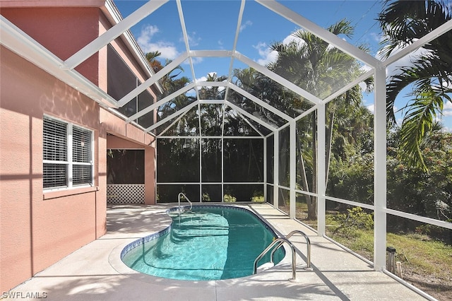 view of pool with a patio and glass enclosure