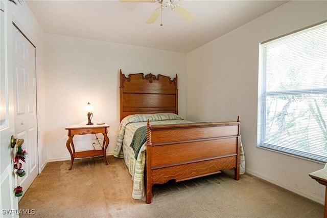 carpeted bedroom with ceiling fan and a closet