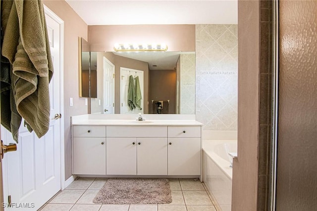 bathroom featuring tile patterned flooring, vanity, a tub to relax in, and tile walls