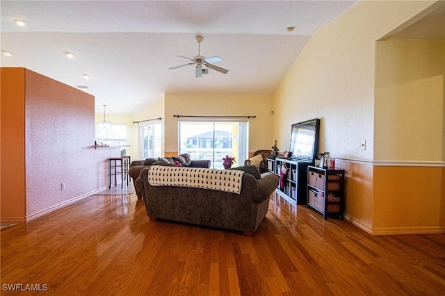 living room with hardwood / wood-style flooring, ceiling fan, and vaulted ceiling