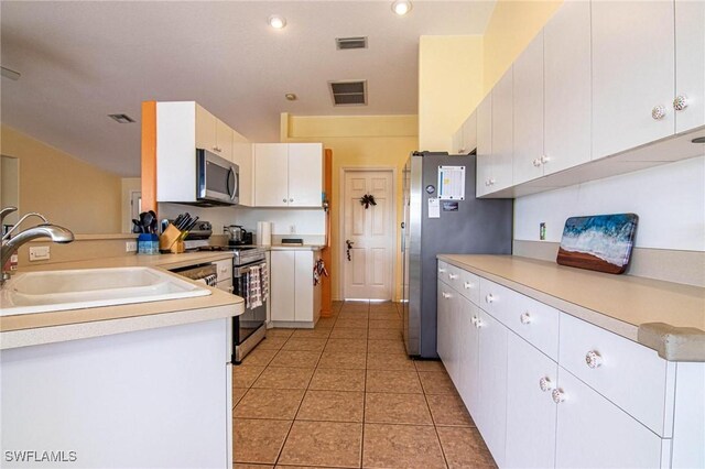 kitchen featuring white cabinets, sink, light tile patterned floors, kitchen peninsula, and stainless steel appliances