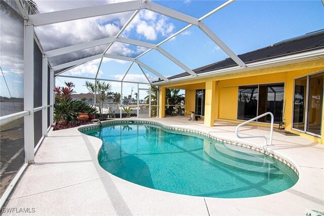 view of pool featuring glass enclosure and a patio area