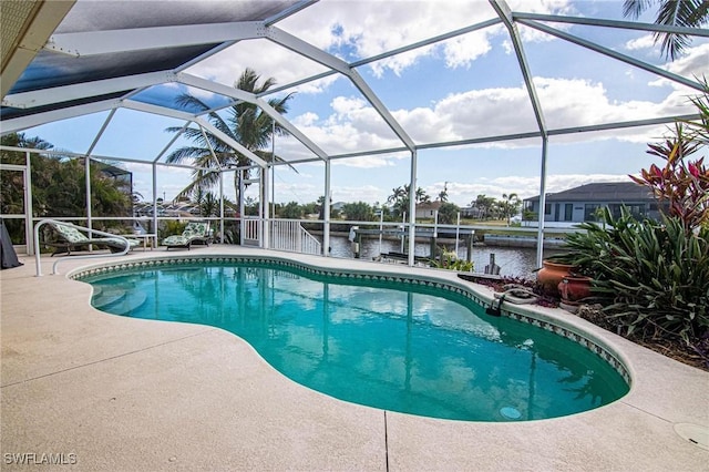 view of swimming pool with glass enclosure, a water view, a patio, and a dock