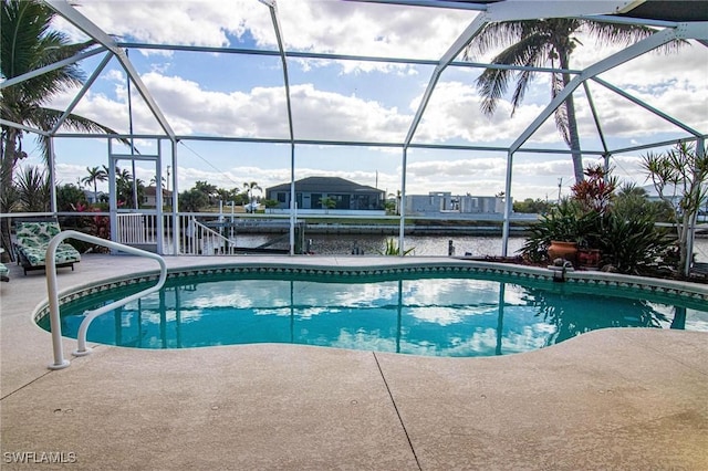 view of swimming pool featuring glass enclosure, a water view, and a patio