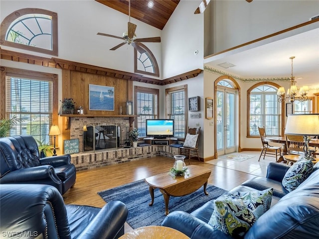 4630 SE 20th Ave, Cape Coral, FL 33904 - living room featuring ceiling fan with notable chandelier, a fireplace, light hardwood / wood-style floors, and a healthy amount of sunlight