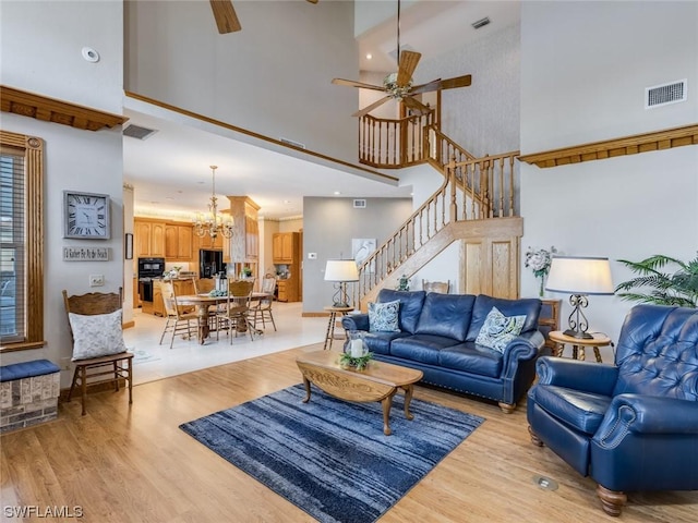 4630 SE 20th Ave, Cape Coral, FL 33904 - living room with a towering ceiling, ceiling fan with notable chandelier, and light hardwood / wood-style flooring