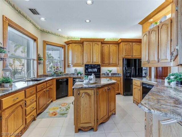 4630 SE 20th Ave, Cape Coral, FL 33904 - kitchen featuring sink, light tile patterned floors, black appliances, light stone countertops, and a kitchen island