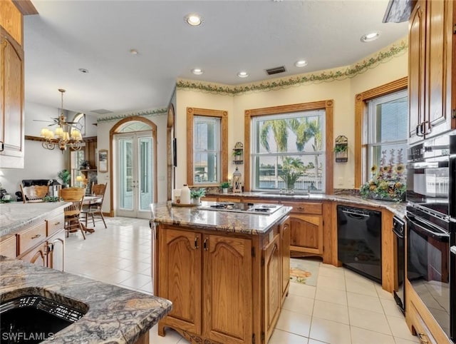 4630 SE 20th Ave, Cape Coral, FL 33904 - kitchen with light tile patterned flooring, decorative light fixtures, a center island, a chandelier, and black appliances