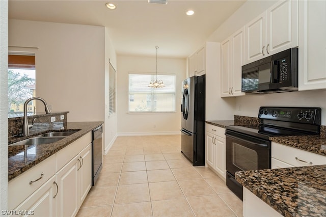 kitchen with decorative light fixtures, black appliances, sink, light tile floors, and a chandelier