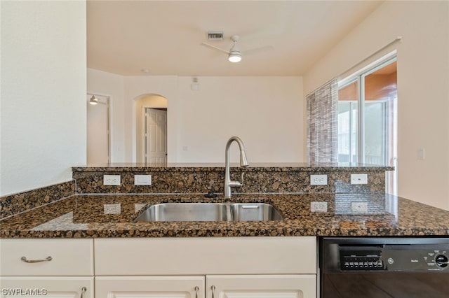 kitchen featuring black dishwasher, ceiling fan, and dark stone countertops