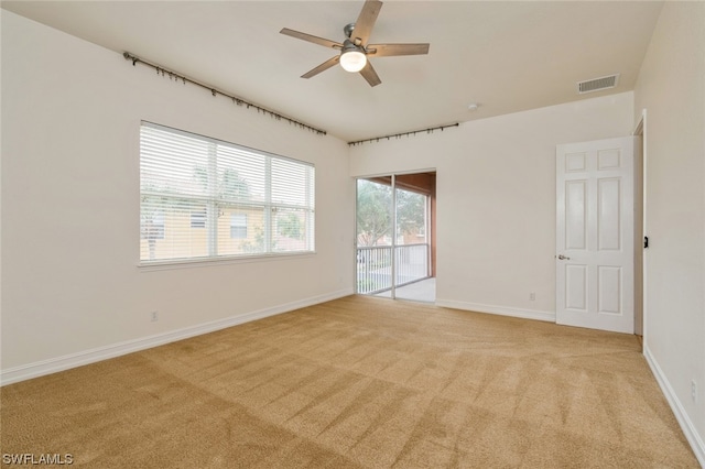 spare room with light colored carpet and ceiling fan