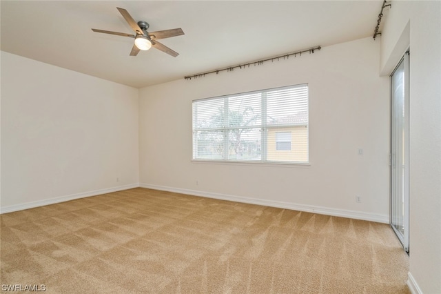 carpeted spare room with ceiling fan