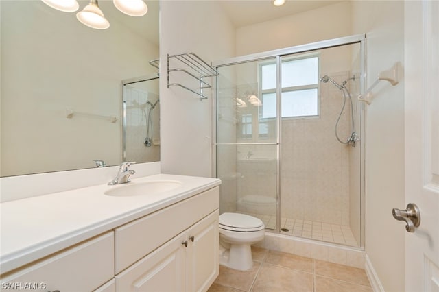 bathroom with toilet, large vanity, tile floors, and a shower with shower door