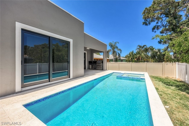 view of swimming pool with an outdoor kitchen and a patio area