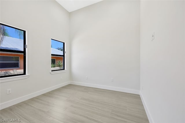 empty room with a high ceiling and light hardwood / wood-style floors