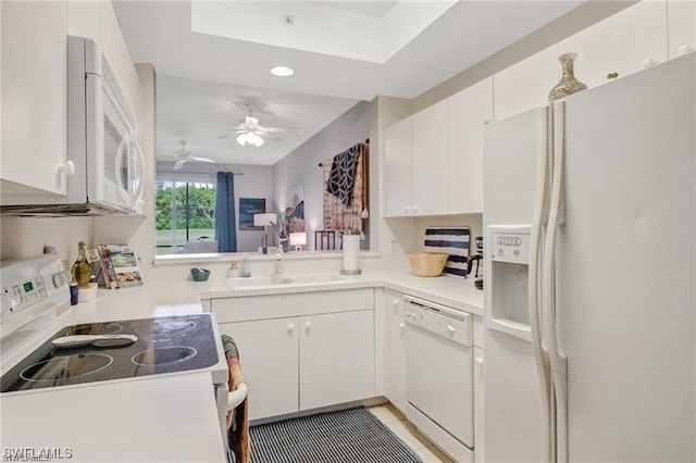 kitchen featuring white appliances, white cabinets, kitchen peninsula, light tile patterned floors, and ceiling fan