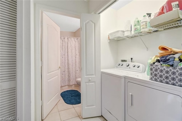 laundry room with washer and dryer and light tile patterned floors