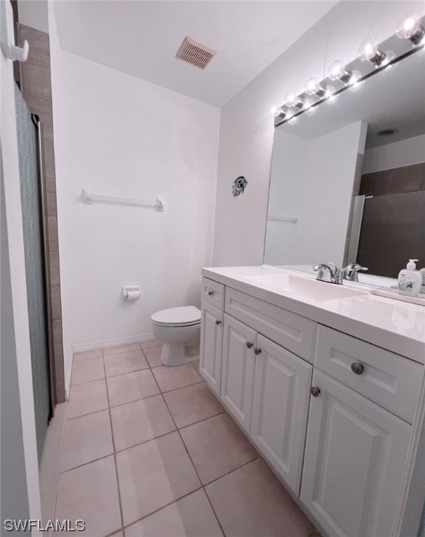 bathroom featuring vanity, tile patterned flooring, and toilet