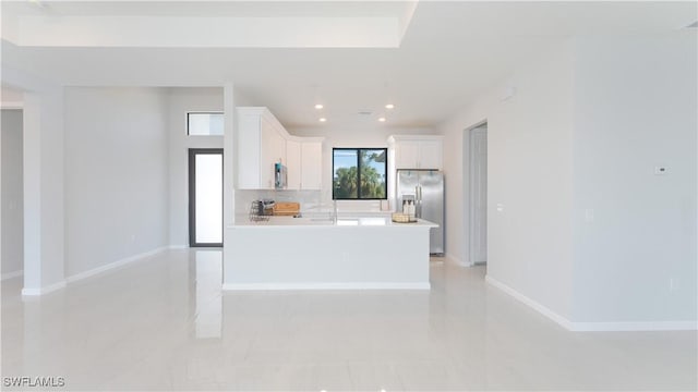 kitchen featuring a kitchen island, stainless steel appliances, decorative backsplash, and white cabinetry