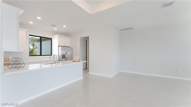 kitchen featuring sink, white cabinetry, and stainless steel refrigerator with ice dispenser