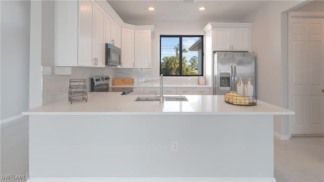 kitchen featuring sink, white cabinetry, kitchen peninsula, and appliances with stainless steel finishes