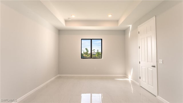 unfurnished room featuring a raised ceiling