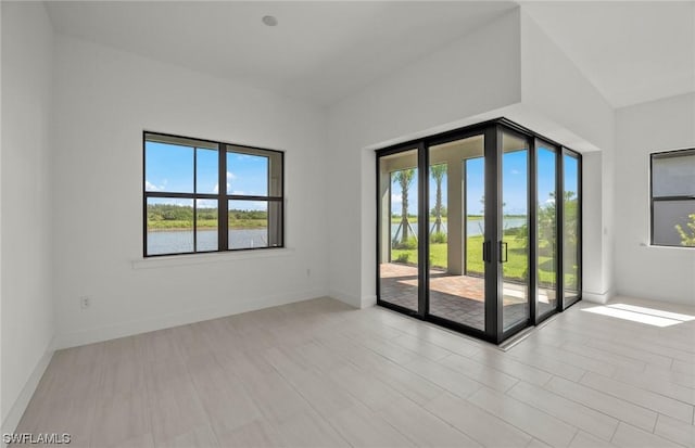 unfurnished room featuring a water view and a wealth of natural light