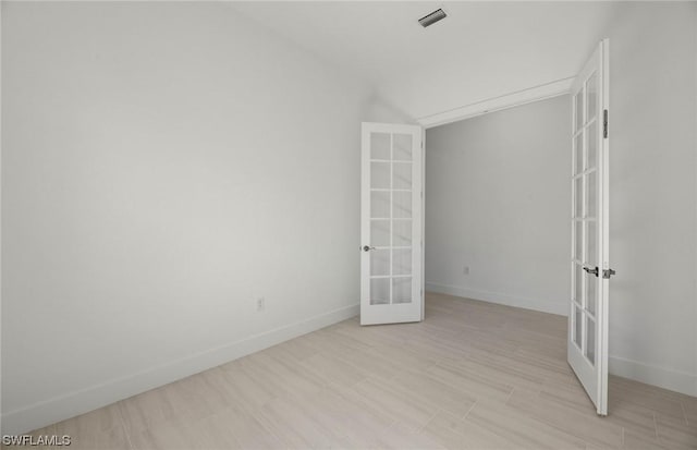 unfurnished bedroom with french doors and lofted ceiling