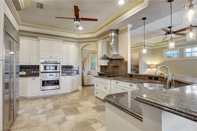 kitchen with white cabinetry, sink, wall chimney exhaust hood, and stainless steel double oven