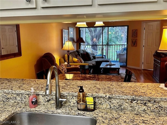 kitchen with dark hardwood / wood-style flooring, light stone countertops, sink, and a wall mounted AC