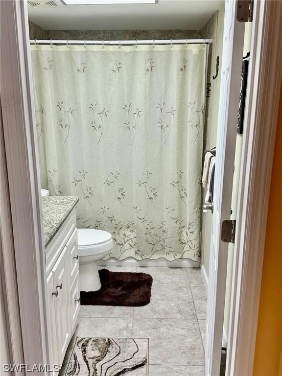 bathroom with tile patterned flooring, vanity, and toilet