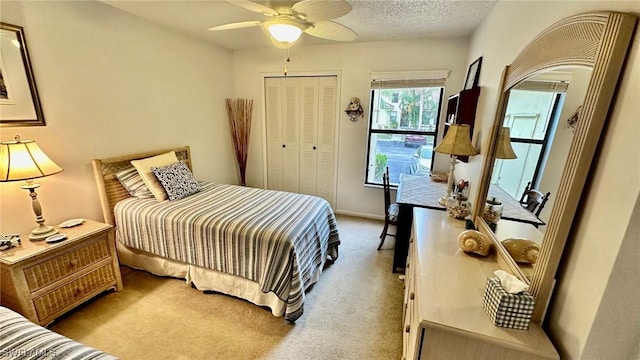 carpeted bedroom featuring a textured ceiling, a closet, and ceiling fan