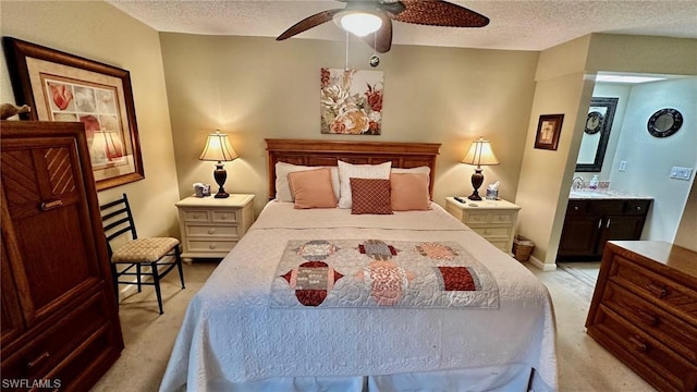 carpeted bedroom featuring ensuite bath, ceiling fan, and a textured ceiling