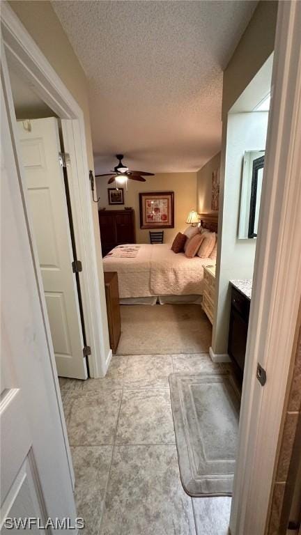 bedroom featuring ceiling fan and a textured ceiling