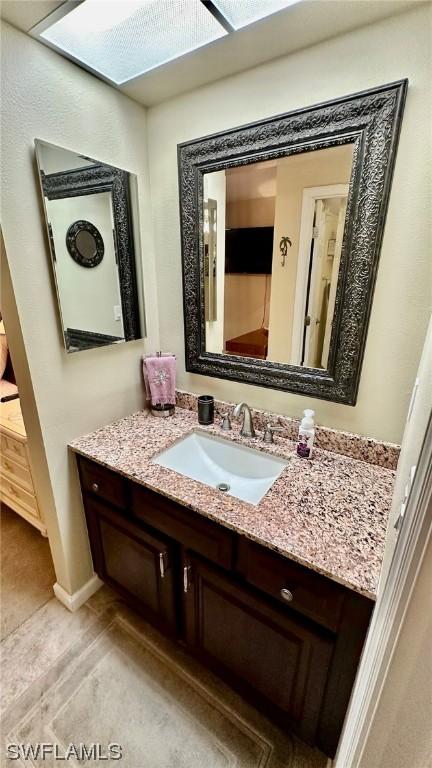 bathroom featuring a skylight and vanity